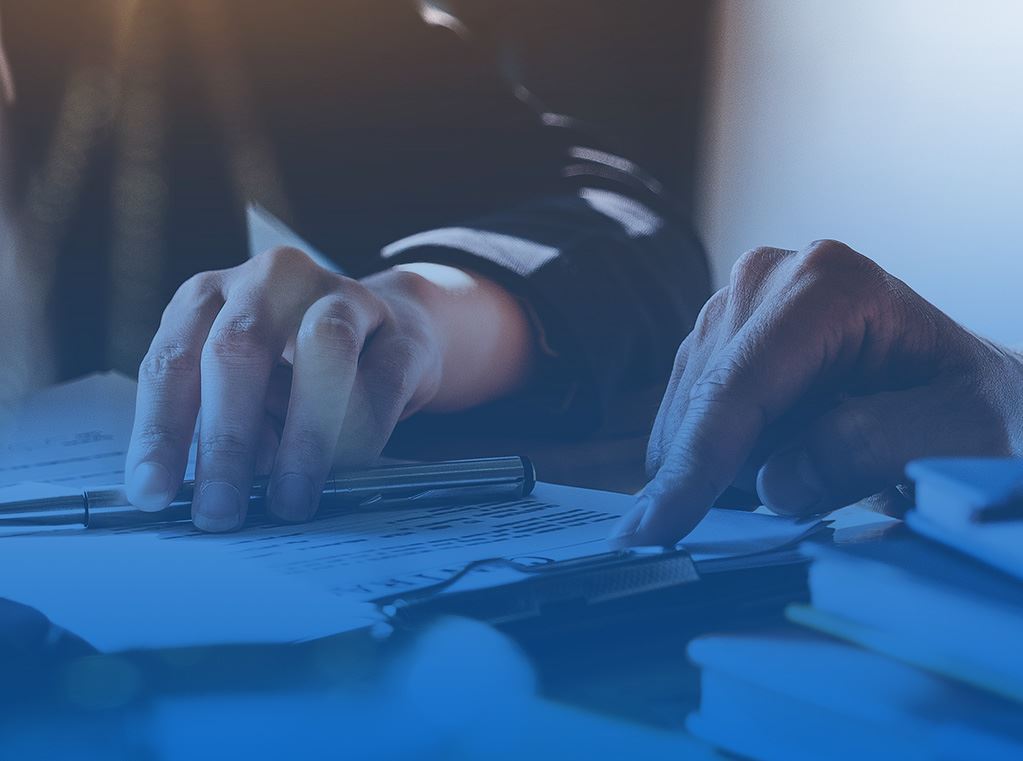 fingers holding down pen and paper